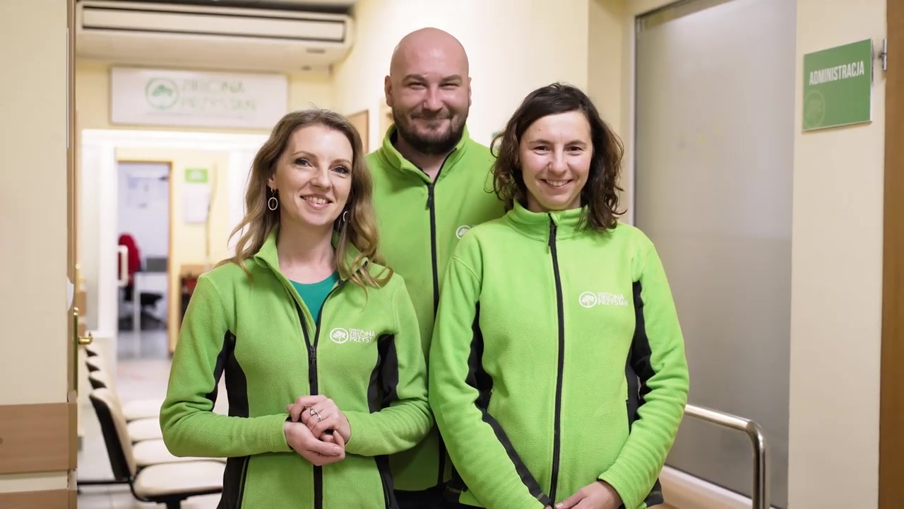 Uśmiechnięty zespół Zielonej Przystani w zielonych bluzach z logo fundacji